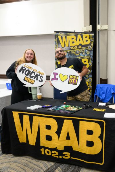 WBAB A man and a woman hold signs reading “Long Island Rocks WBAB” and “I love 106.1 WBLI